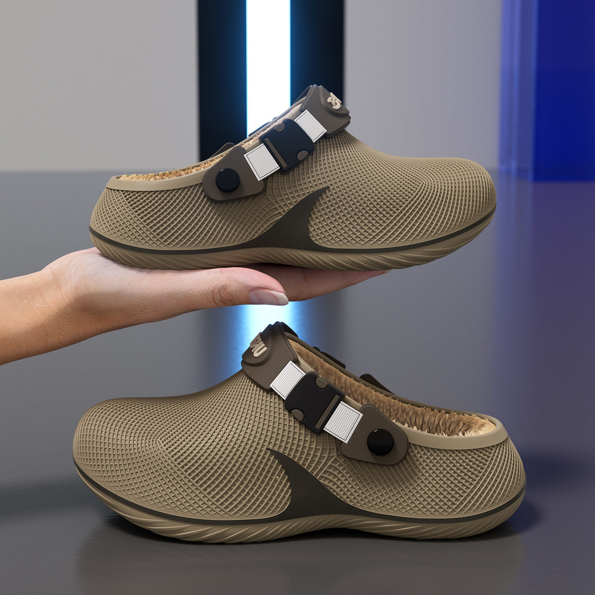 Two tan plastic slippers with textured surfaces and fleece lining, one held in a hand and one resting on a grey surface.